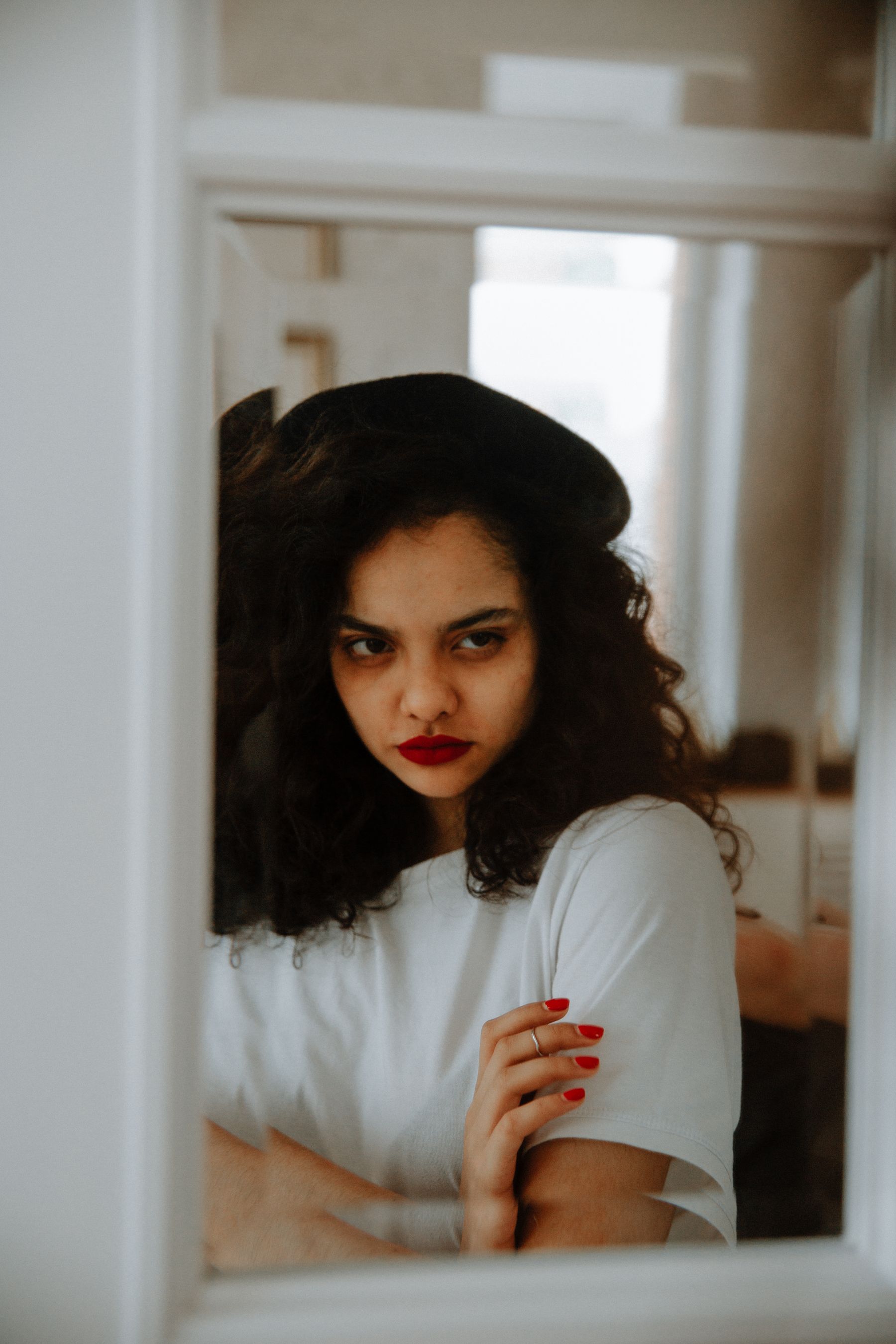Woman with curly hair reflected in a mirror